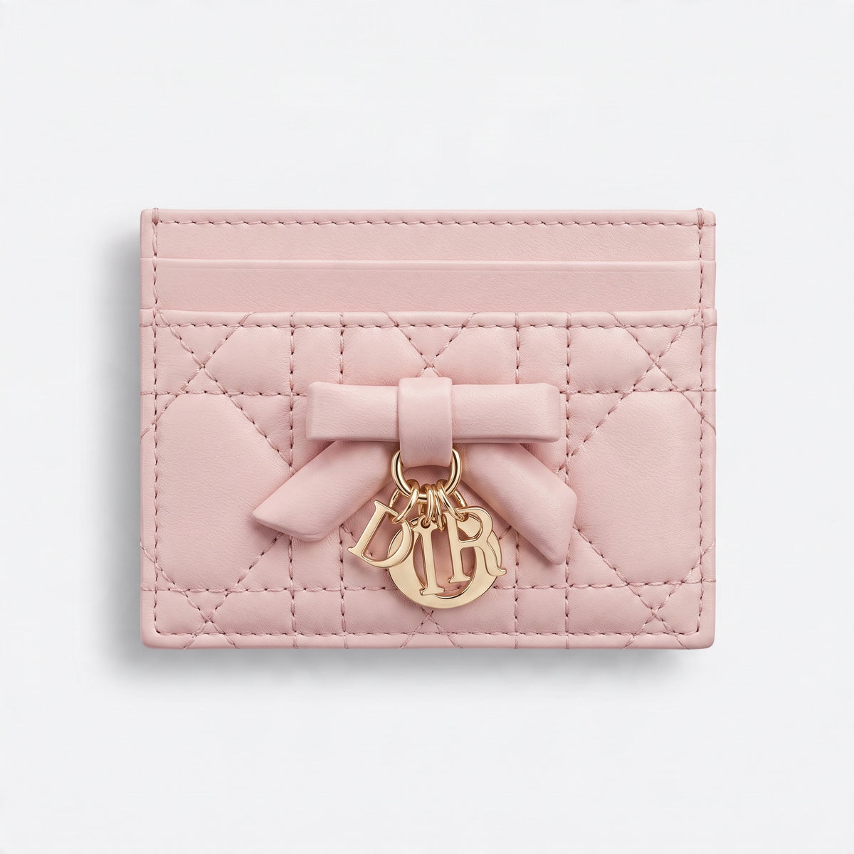 pink quilted Dior card holder with bow and gold letter charms