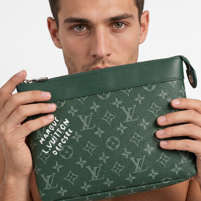 Green Louis Vuitton monogram pouch with top zipper and white printed text held by male model