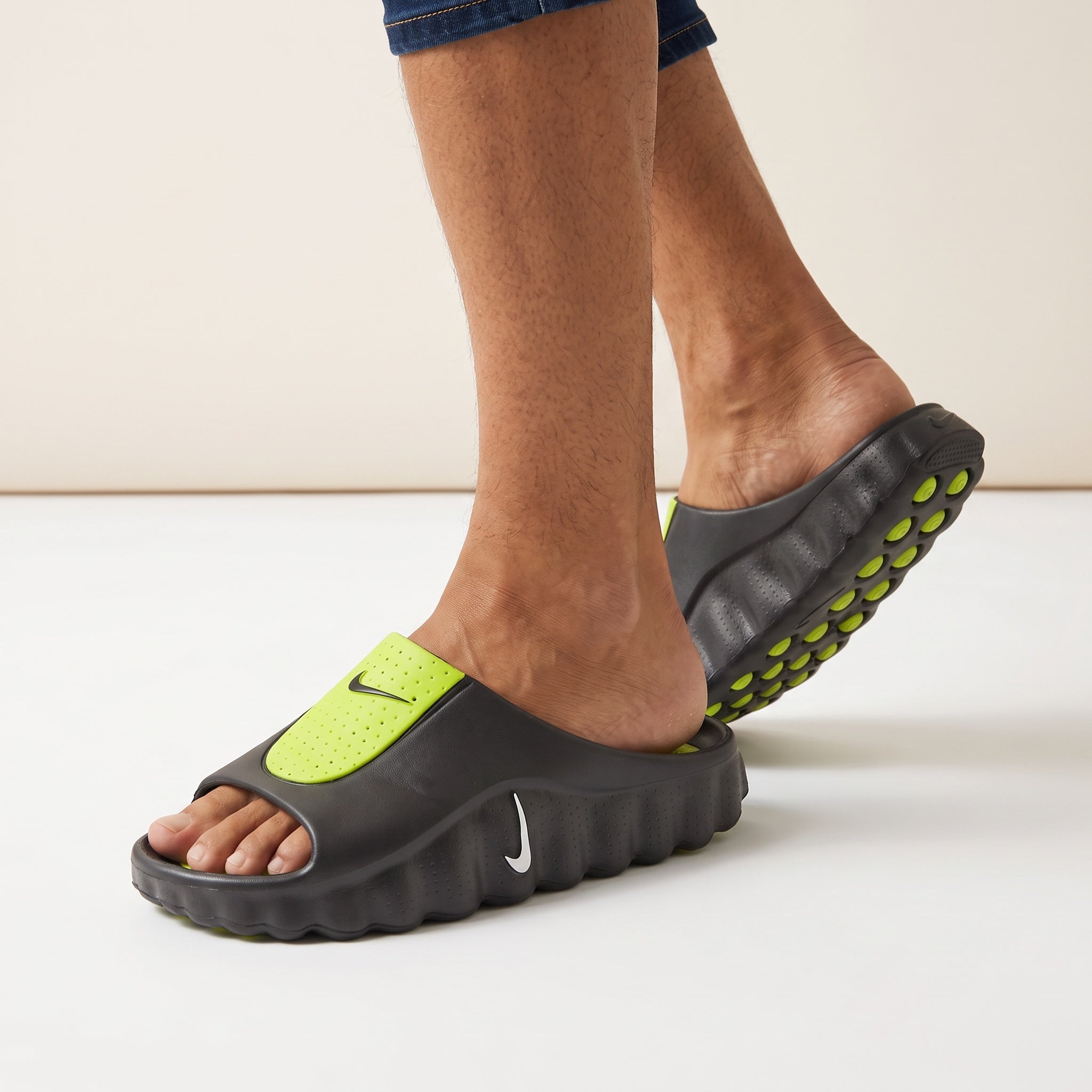 black Nike slide with volt green perforated strap and studded outsole