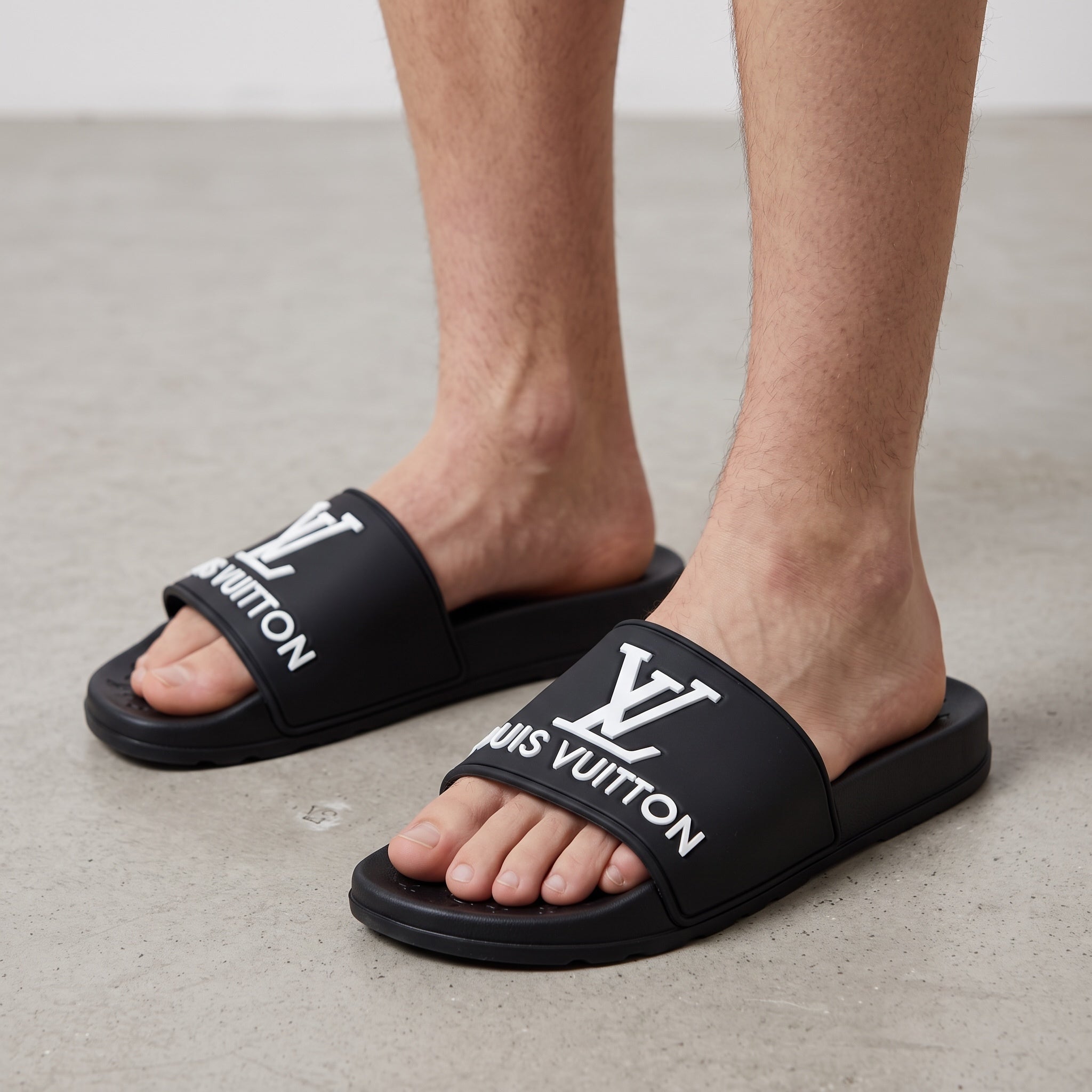 Black Louis Vuitton slides with white LV logo across strap