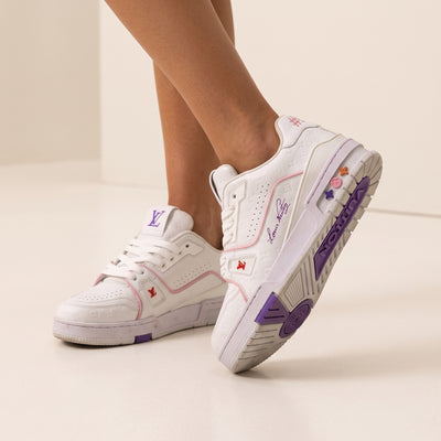 White Louis Vuitton low-top trainer with pink piping, purple sole accents and embossed monogram
