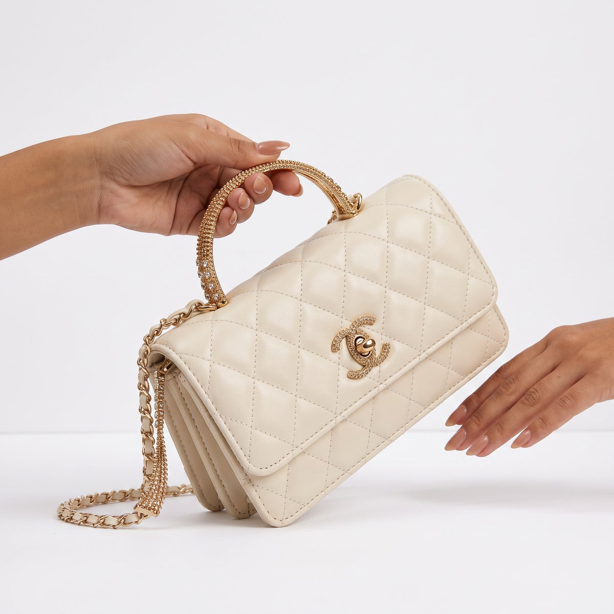 Cream quilted Chanel mini flap bag with gold crystal-accent handle and chain strap