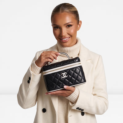 black quilted Chanel vanity case with white trim and CC logo