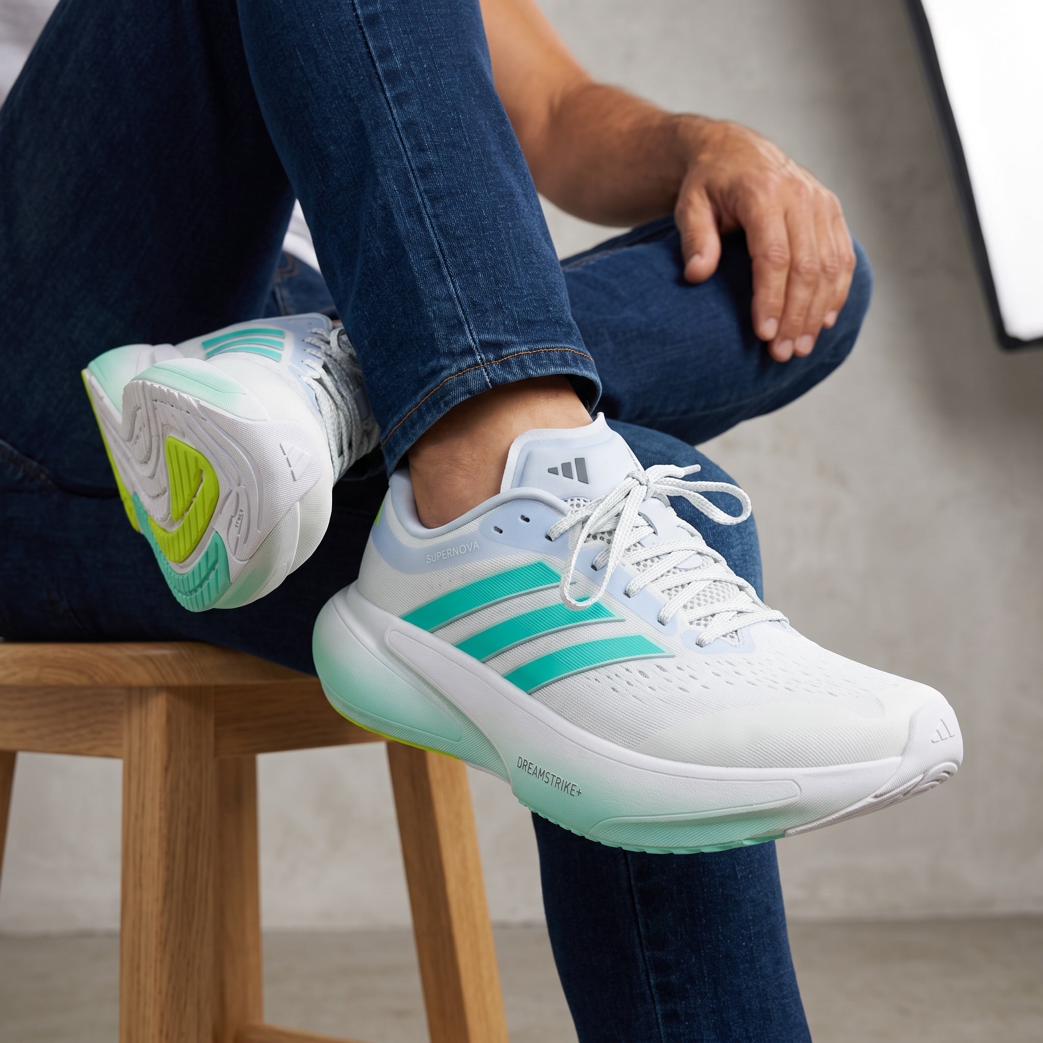 Adidas Supernova white sneakers with teal stripes and cushioned sole