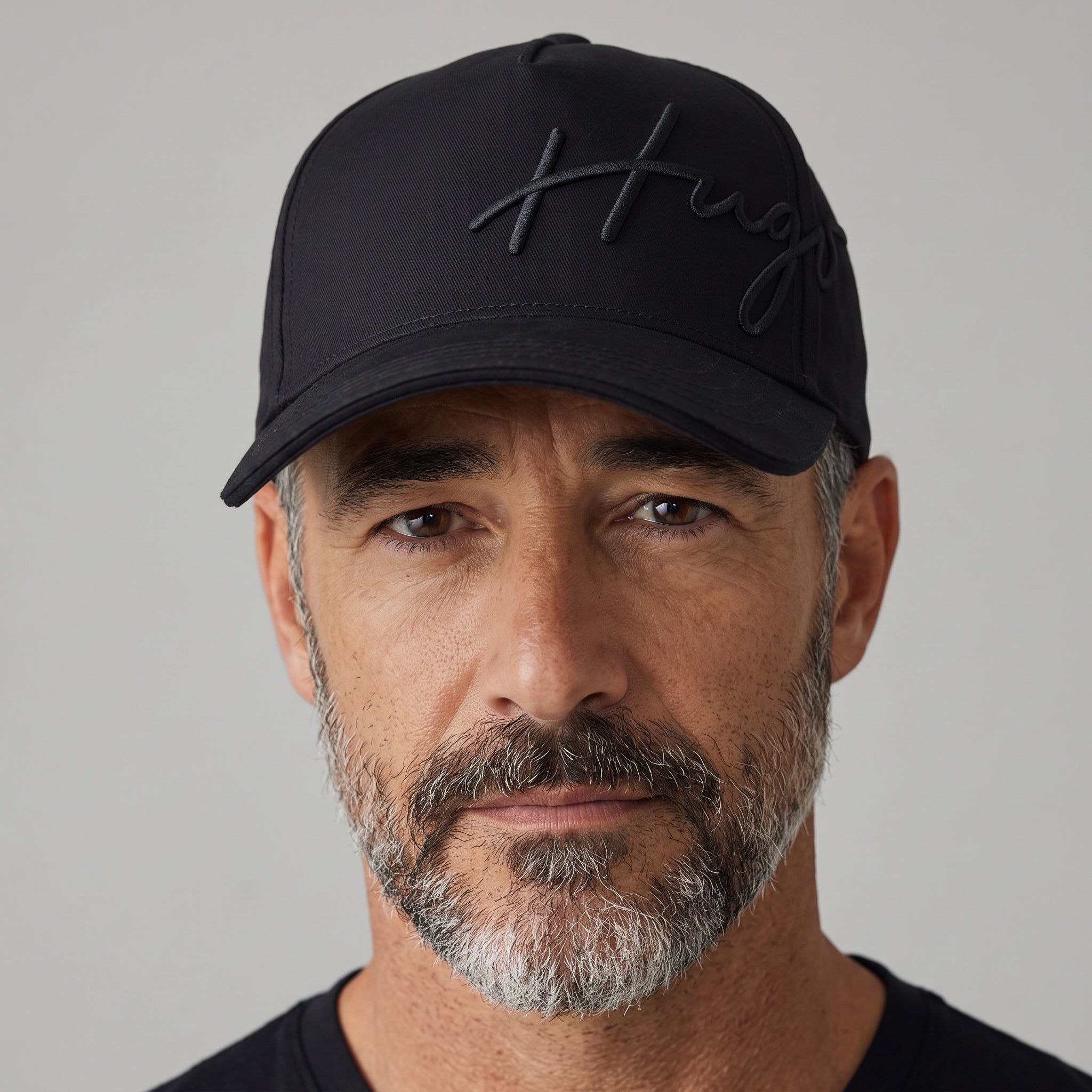 Man wearing a black Hugo Boss baseball cap with embroidered script logo