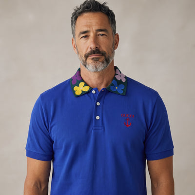 Men's royal blue Gucci polo with multicolour floral knit collar and embroidered chest logo