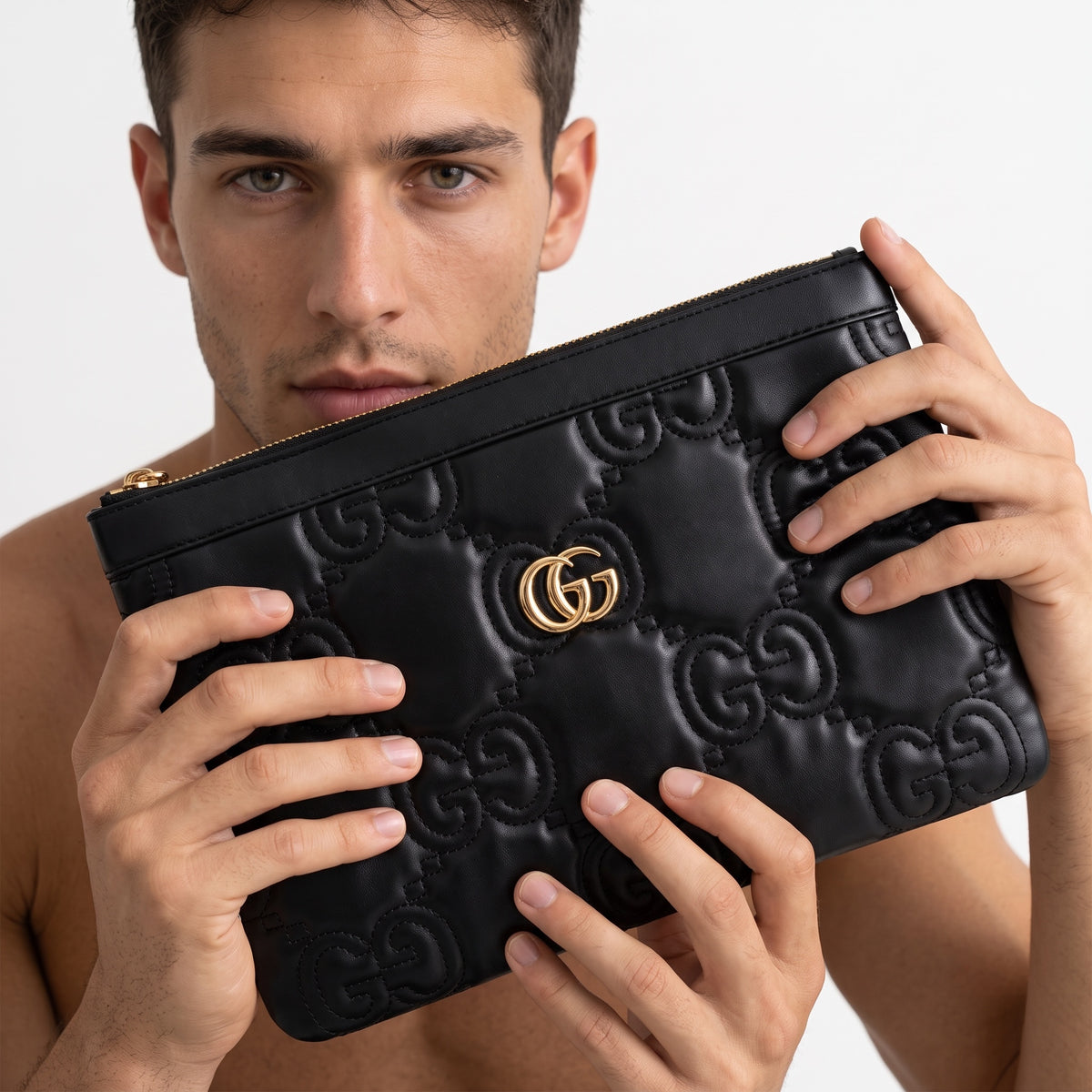 Black Gucci quilted GG zipper pouch clutch held by model