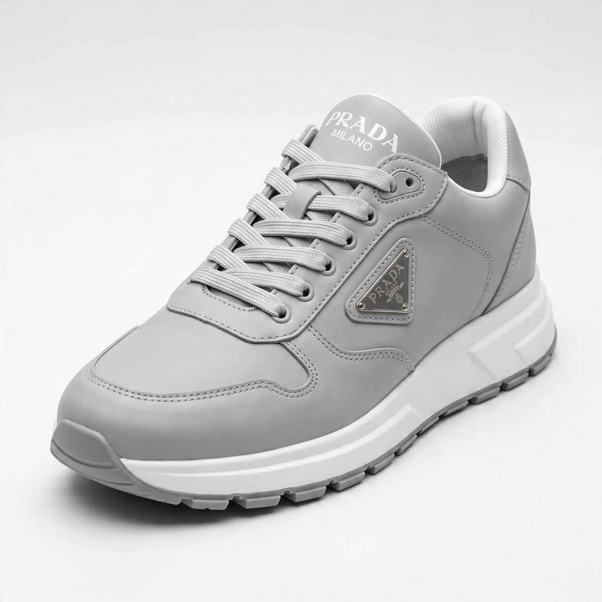 Prada grey low-top sneakers with triangular logo plaque and chunky white sole