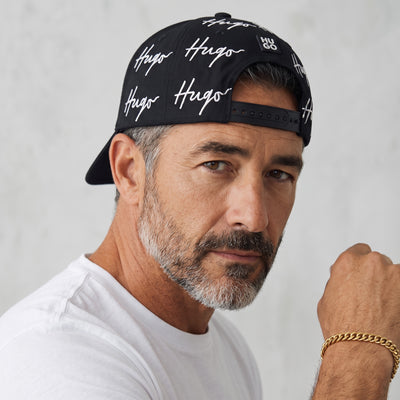 Black HUGO baseball cap with repeated white signature logo print