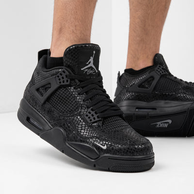 Black Air Jordan 4 Retro with snakeskin pattern and Jumpman tongue logo