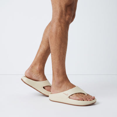beige Nike foam slide with brown sole and metallic Swoosh