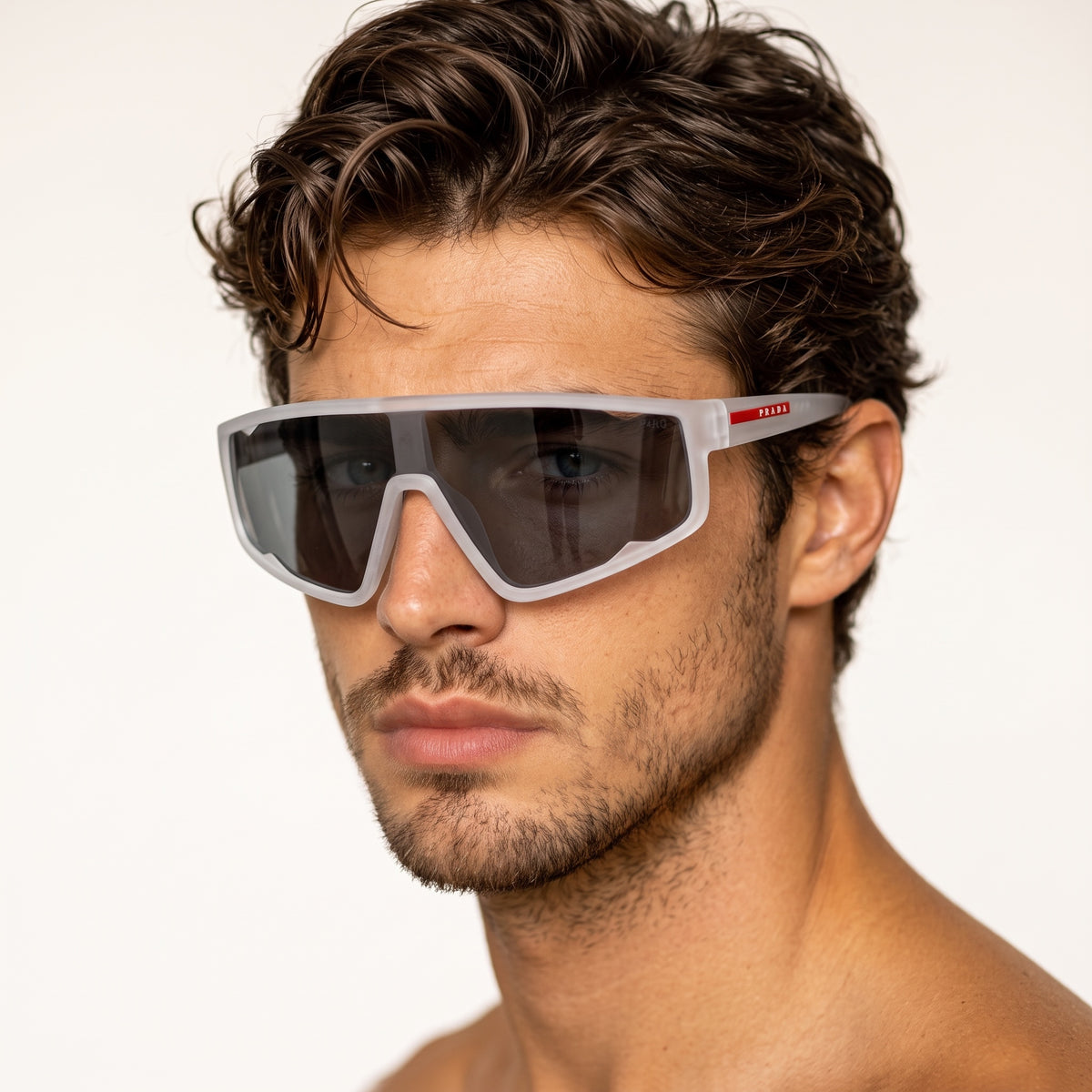 Prada oversized translucent white shield sunglasses with dark lens and red logo on temple.