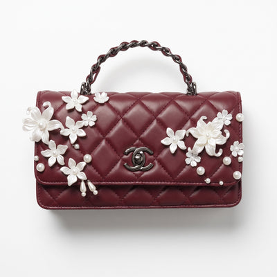 burgundy quilted Chanel top-handle flap bag with pearl floral appliqués and CC turn-lock