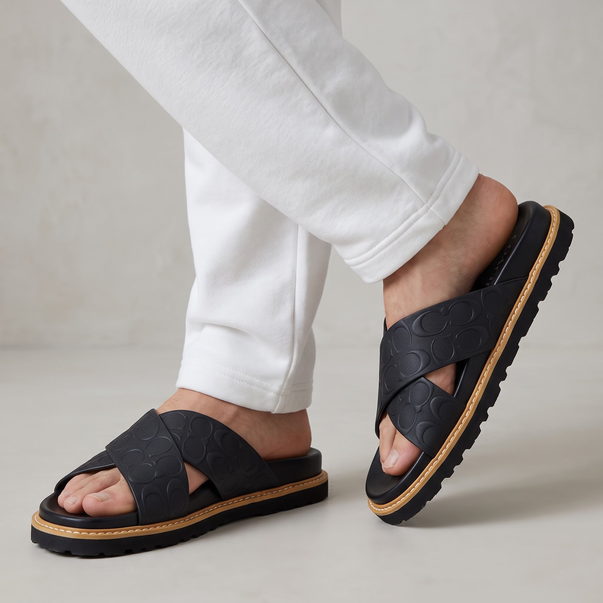 black Coach embossed logo crossover slide sandal with chunky treaded sole