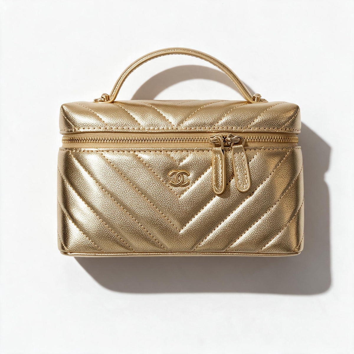 Gold quilted Chanel vanity case with top handle and double zip