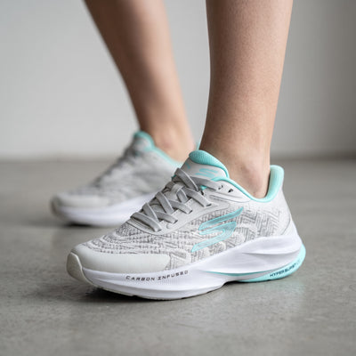 Light grey Skechers sneakers with aqua trim visible carbon infused and hyper burst markings