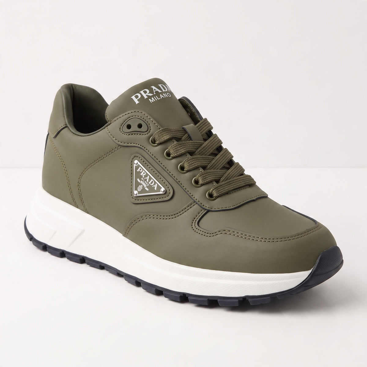 Olive green Prada low-top trainer with white chunky sole and triangular logo plaque