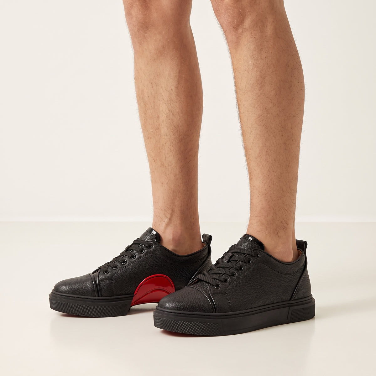 black low-top leather sneakers with red sole and red midsole detail