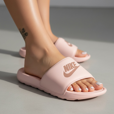 pale pink Nike slide sandals with cushioned footbed and Nike logo on strap