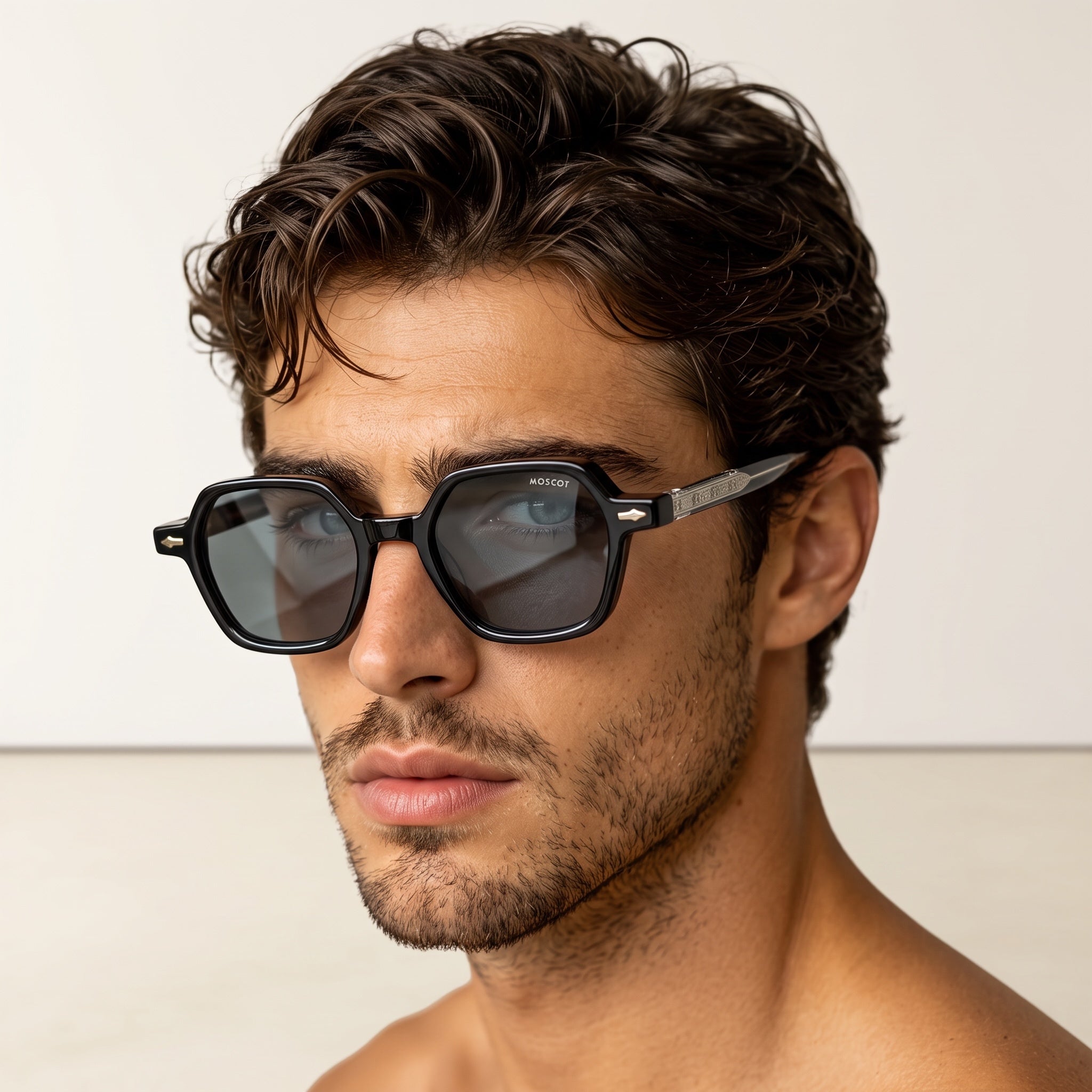 Close-up of man wearing black Moscot square sunglasses with grey lenses