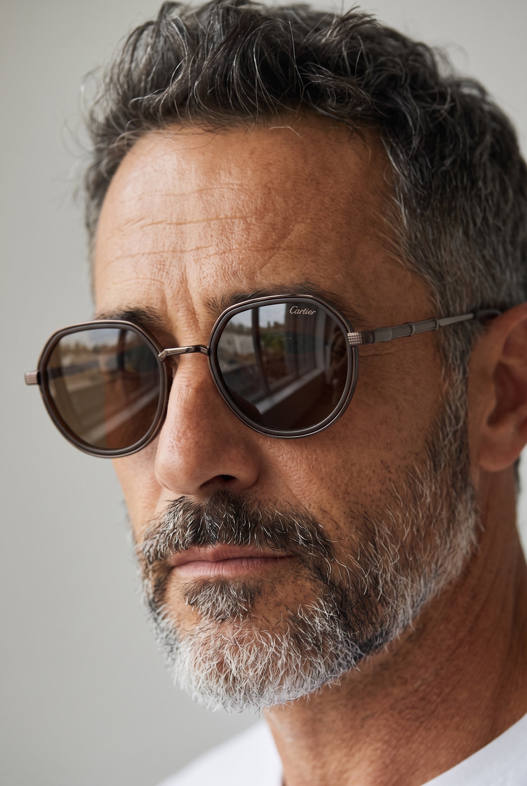 Close-up of man wearing Cartier brown round sunglasses with metal temples