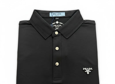 MASTERPIECE black Prada polo shirt with signature chest logo, classic collar, and button placket. Made from breathable stretch fabric.