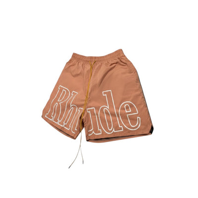 MASTERPIECE brown quick-dry swim shorts with oversized white Rhude logo and yellow drawstring.