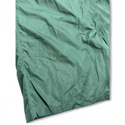 MASTERPIECE green technical fabric swim shorts with tonal monogram pattern, elastic waistband, and drawstring.