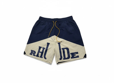 MASTERPIECE navy and cream color-blocked swim shorts with large RHUDE logo and yellow drawstring.