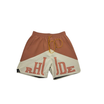 MASTERPIECE Rhude panel swim shorts in rust brown and cream with oversized RHUDE logo and yellow drawstring.
