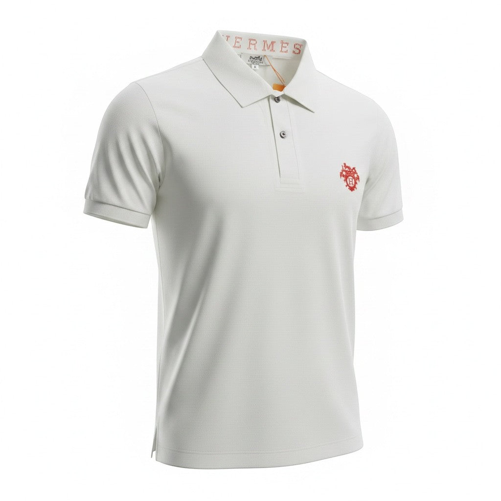 MASTERPIECE white polo shirt with red crest logo on chest, classic collar, and signature Hermès detail inside collar. Premium breathable fabric.
