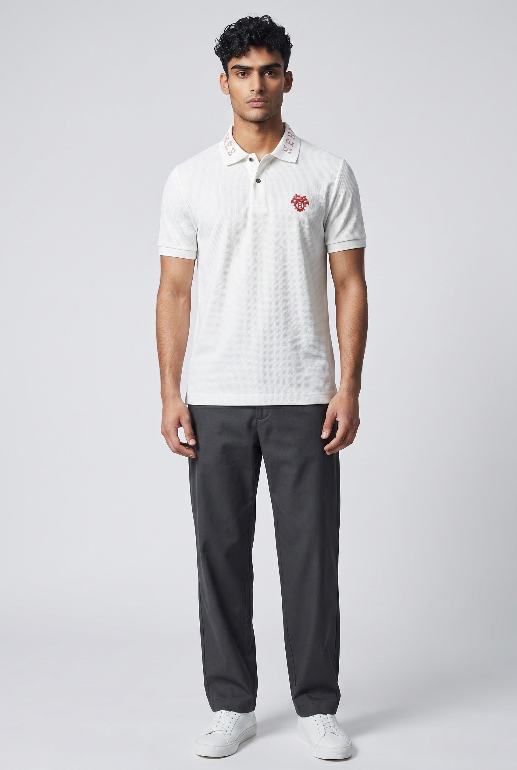 MASTERPIECE white polo shirt with red embroidered crest logo on chest and red Hermès logo on collar. Premium breathable fabric.